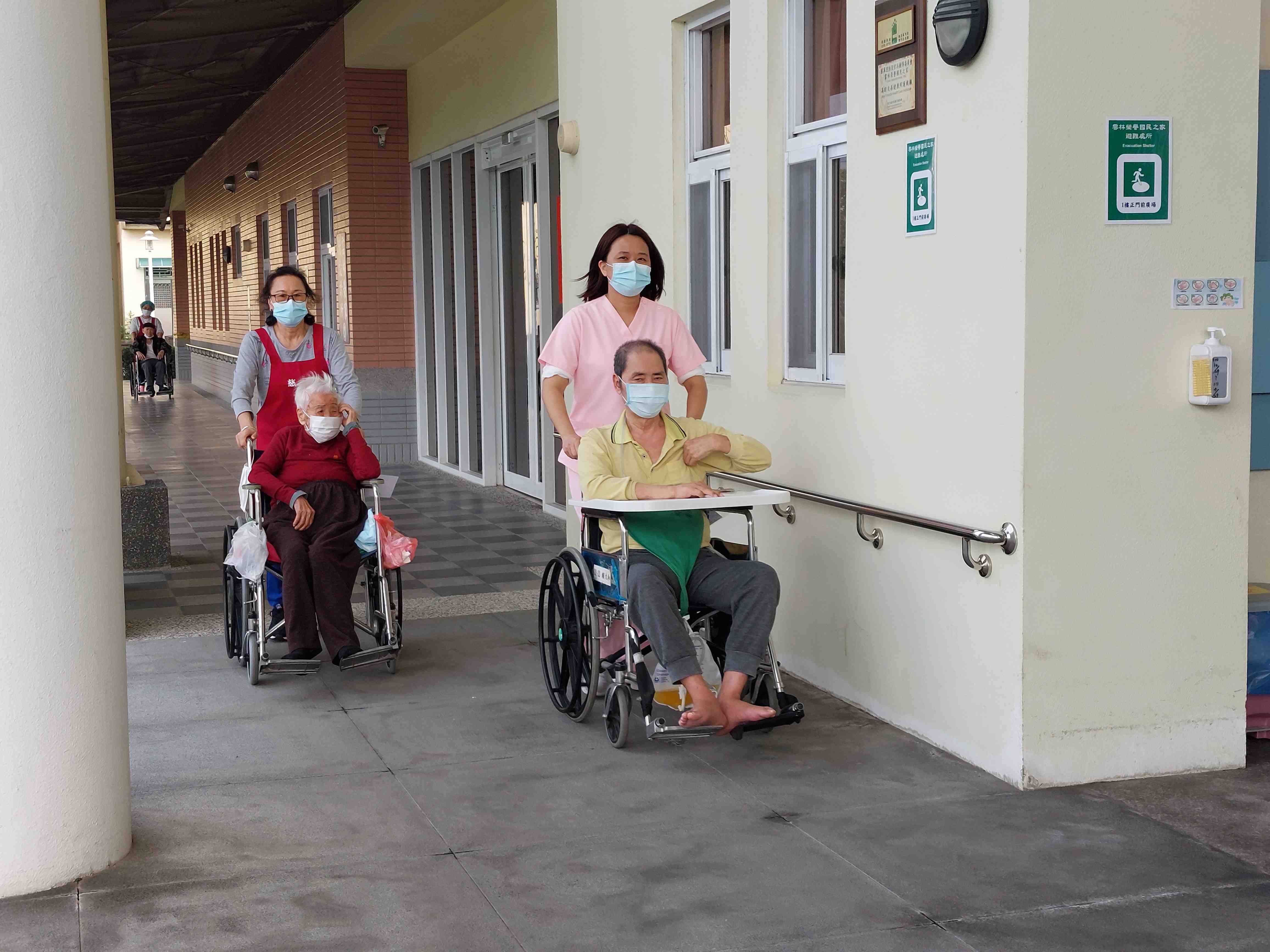 護理師及照服員推坐輪椅住民參加健走活動