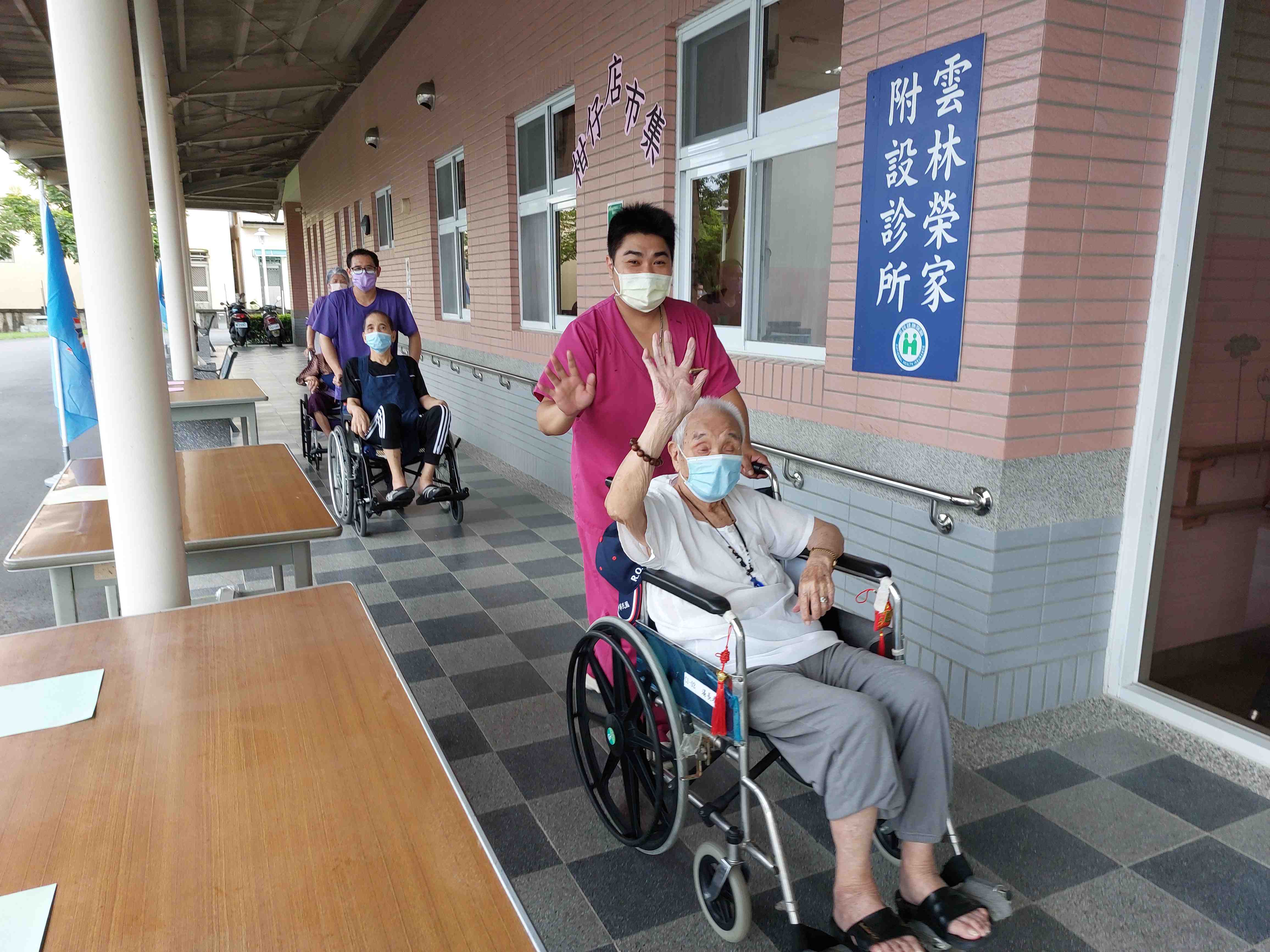 委外工作人員推坐輪椅住民參加健走活動