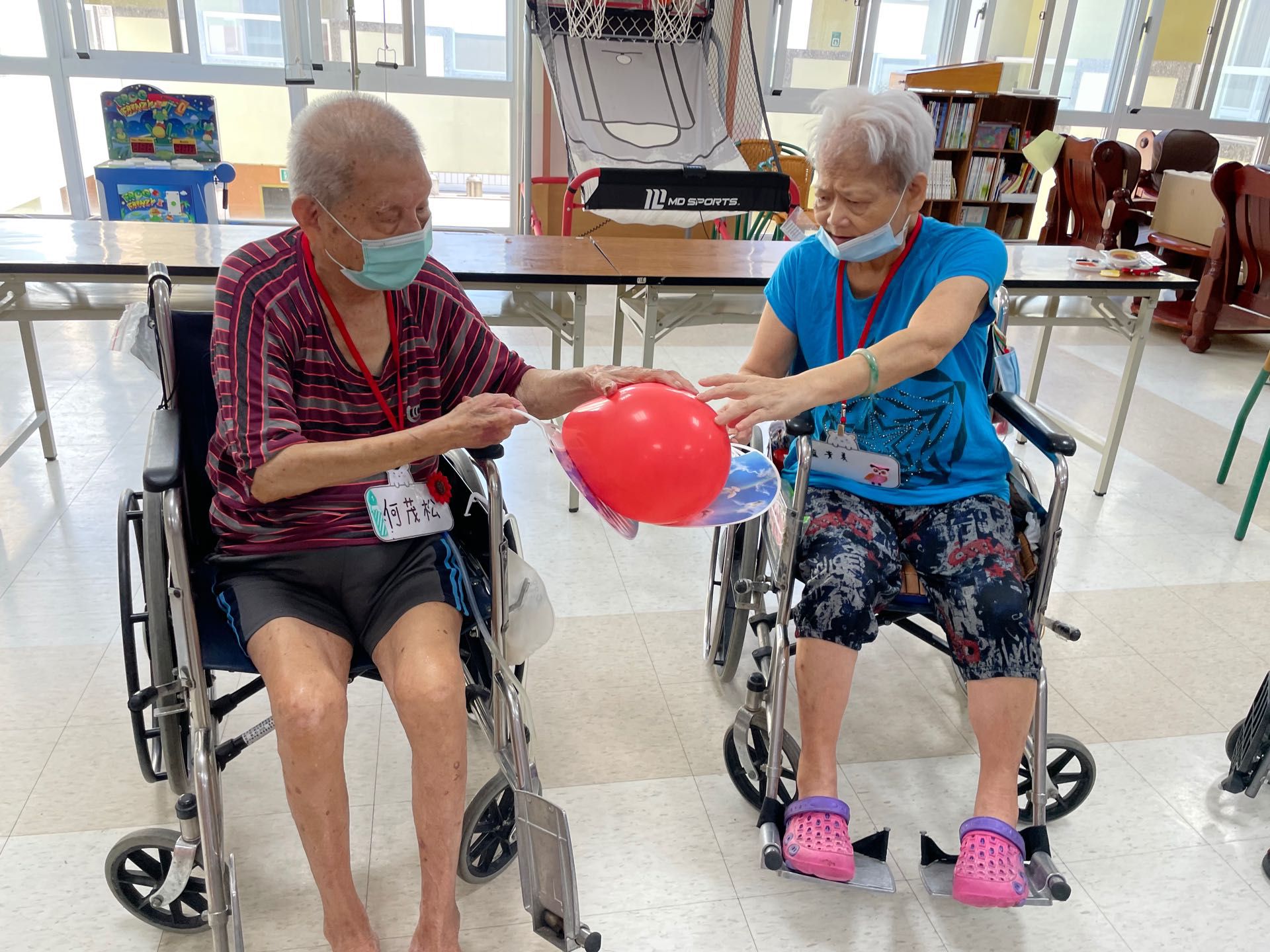 扇子傳氣球的活動，讓長輩團結合作完成，訓練長輩的專注力。