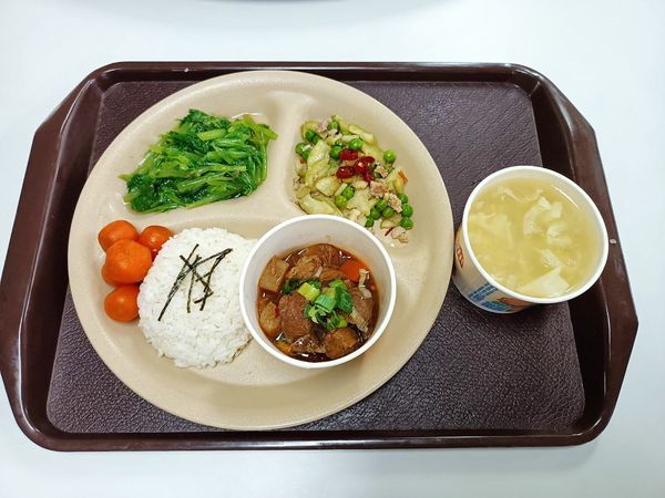 牛腩匯飯搭配醃瓜、梅汁紅蘿蔔球、蔬菜、玉米濃湯，伯伯們專心享受美味午餐