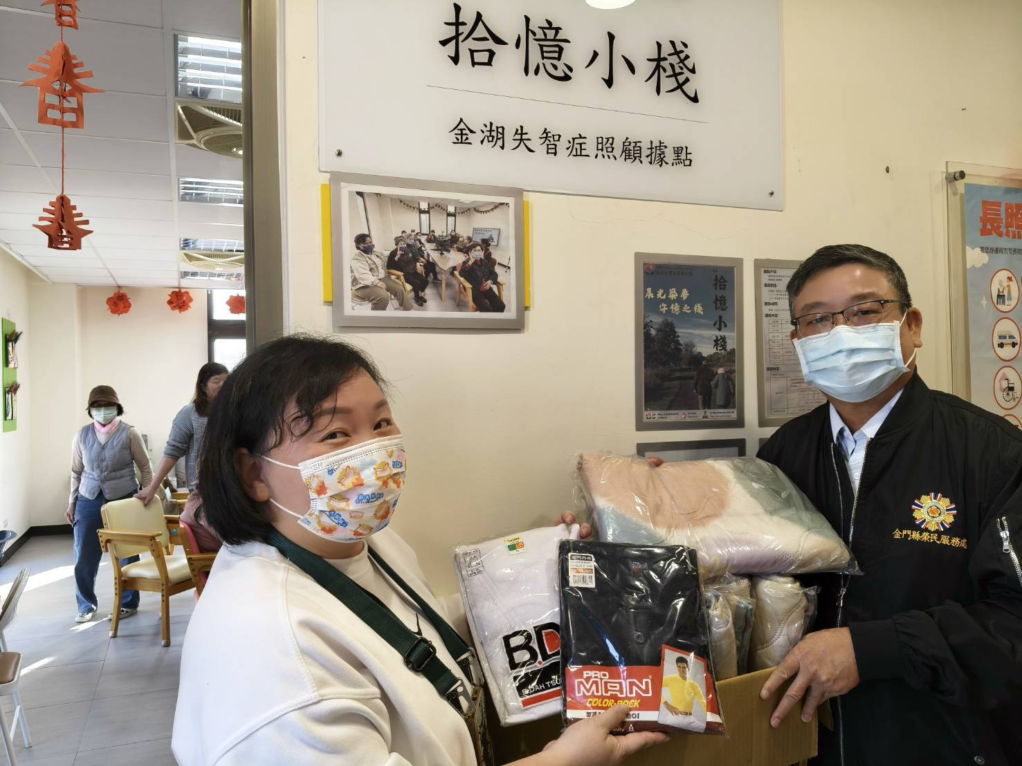 圖二劉信義處長(右)走訪金湖失智社區服務照護據點贈榮民禦寒衣物並與該機構陳麗敏社工員合影