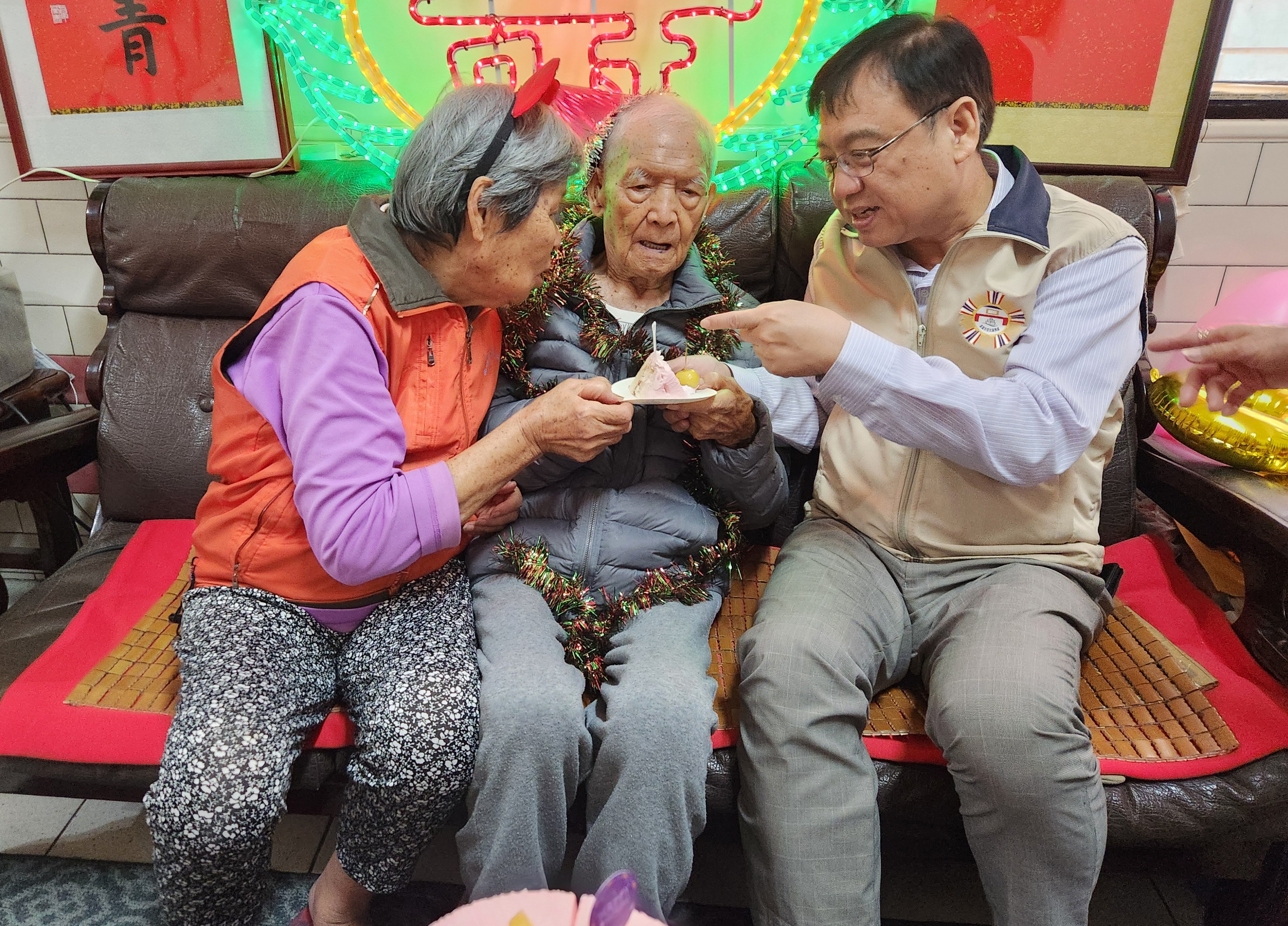 高雄市榮民服務處劉雅魁處長(右)與壽星吳爺爺(中)一同享用蛋糕