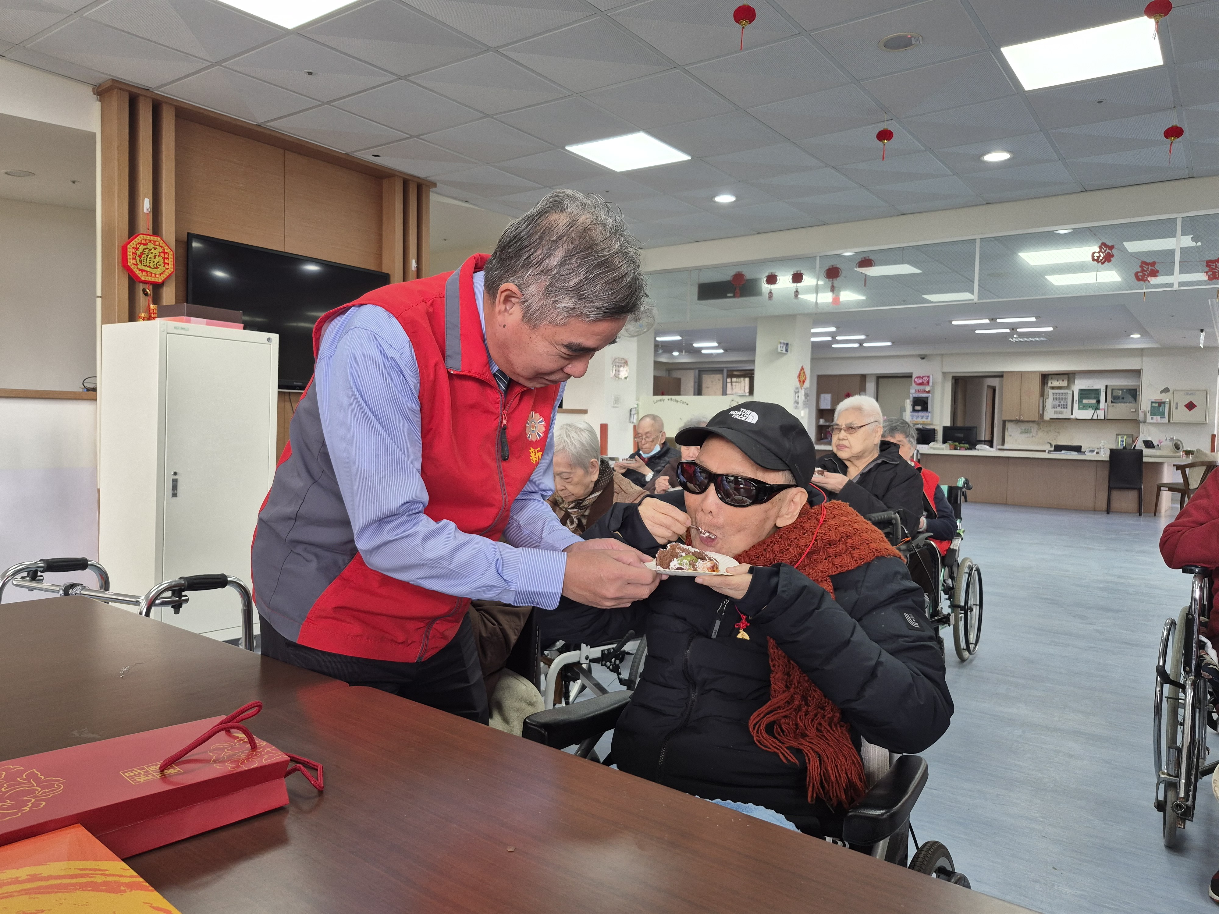 金爺爺(右)享用美味壽糕,林處長(左)陪同在側。