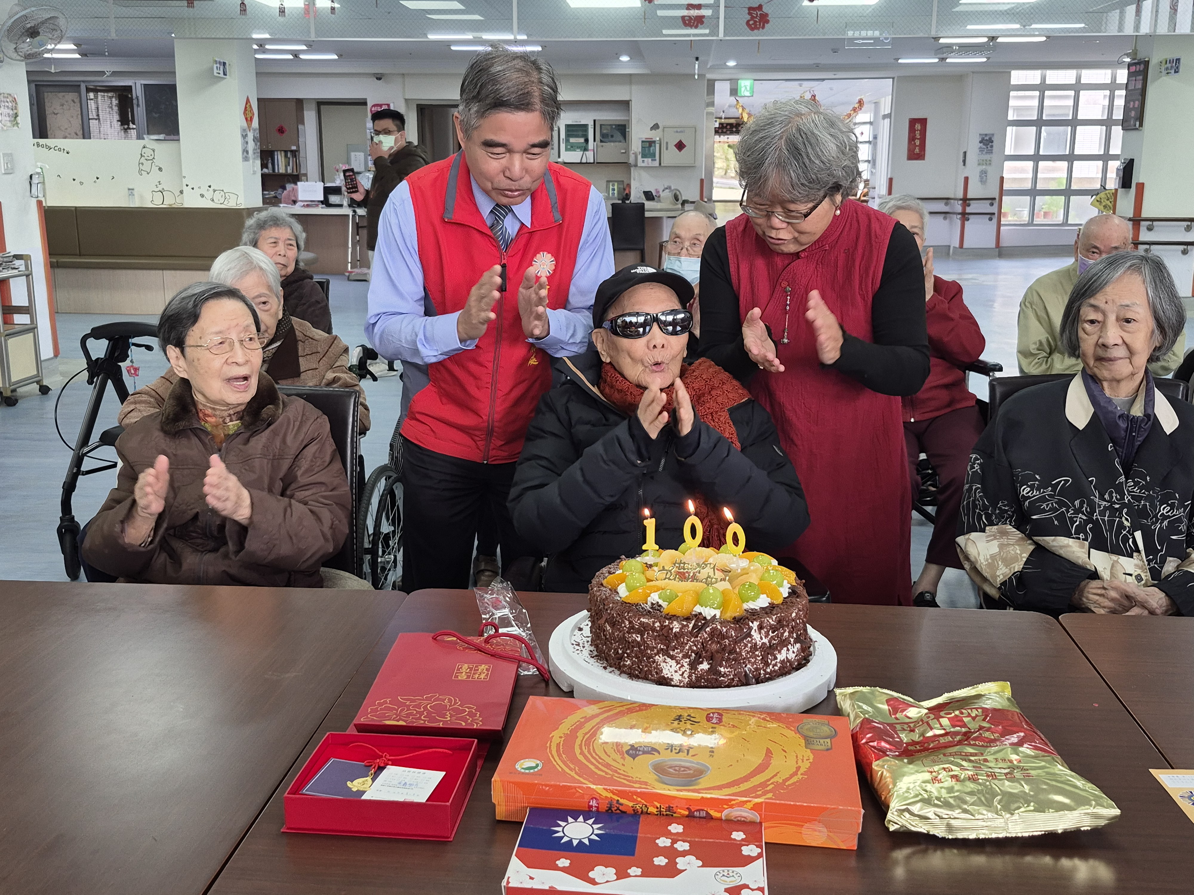 金爺爺(中)與林處長(左2)翠柏新村老人安養中心主任王儀玲(右2)住民一齊合唱生日快樂歌。