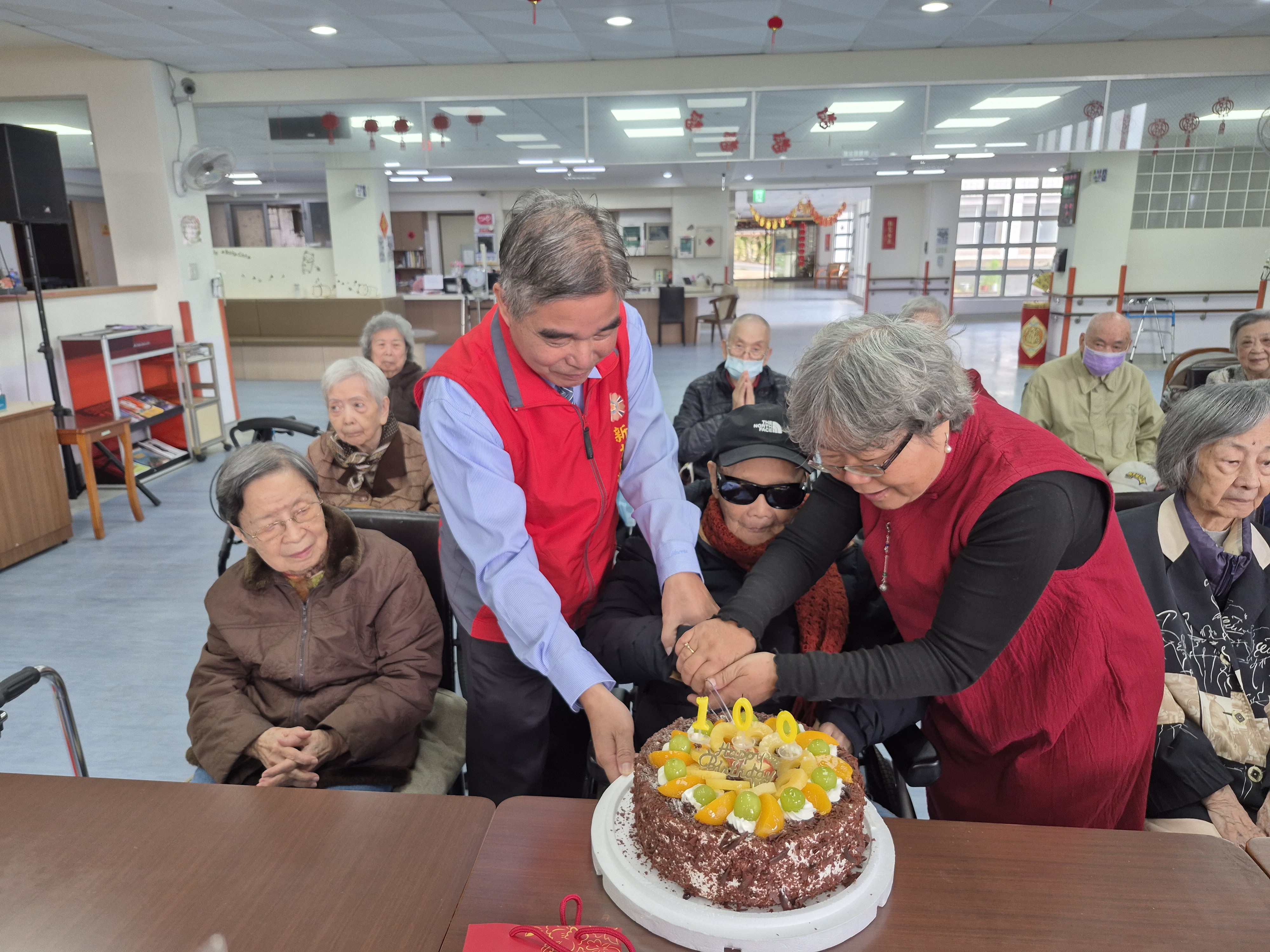 金爺爺(中)與林處長(左2)及翠柏中心主任王儀玲(右2)一同切壽糕,氣氛溫馨融洽。
