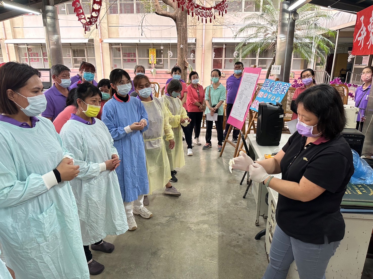 圖4:保健組組長(右)對工作人員進入隔離室著裝。