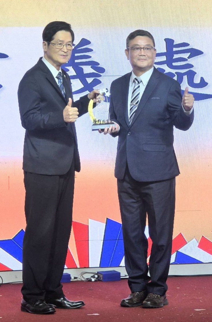 圖二嚴德發主任委員(左)頒發劉信義處長(右)績優運用單位獎項