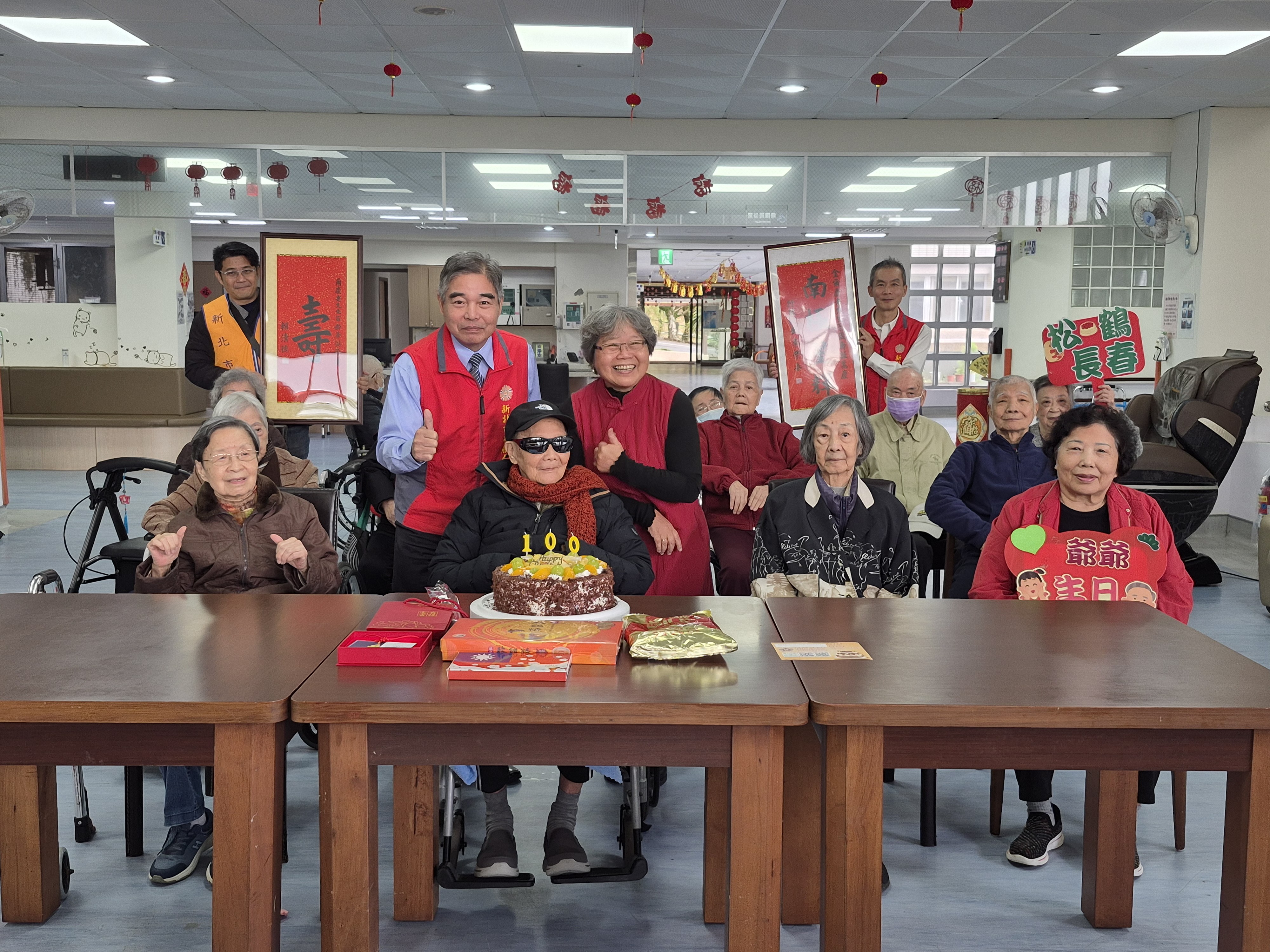 林處長(後排左)率責任區輔導員、社區服務組長等一行人,與翠柏新村老人安養中心主任王儀玲(後排右),共同向金爺爺(前排左2)祝賀壽誕。