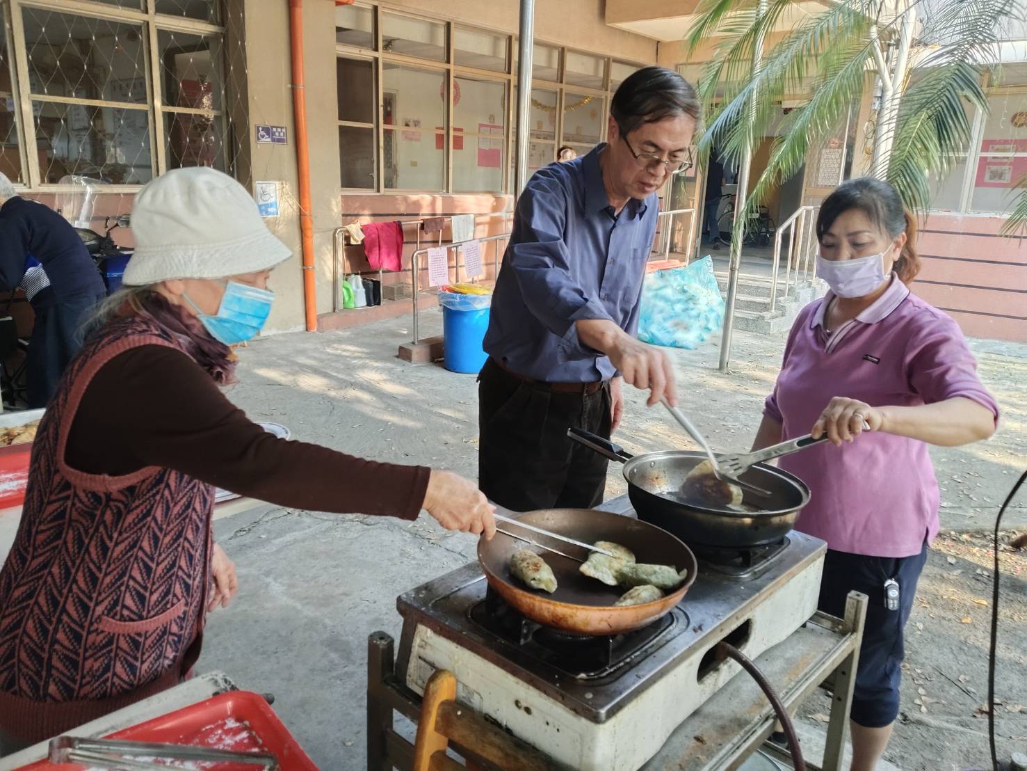 圖1:家主任李秦強(中)與長輩一同煎韭菜盒子
