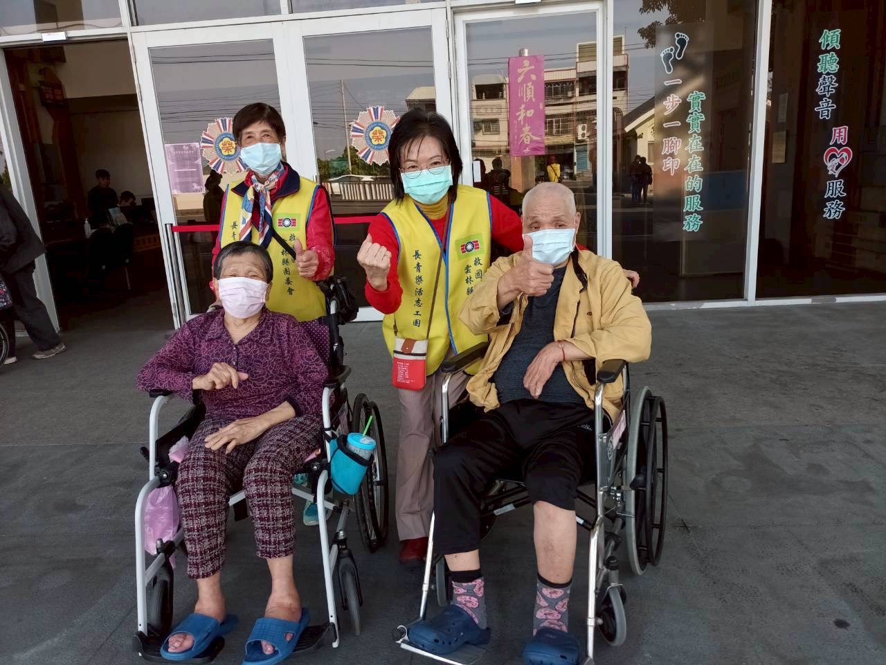 志工與長輩於門口開心比讚合影,留下充滿活力的回憶。