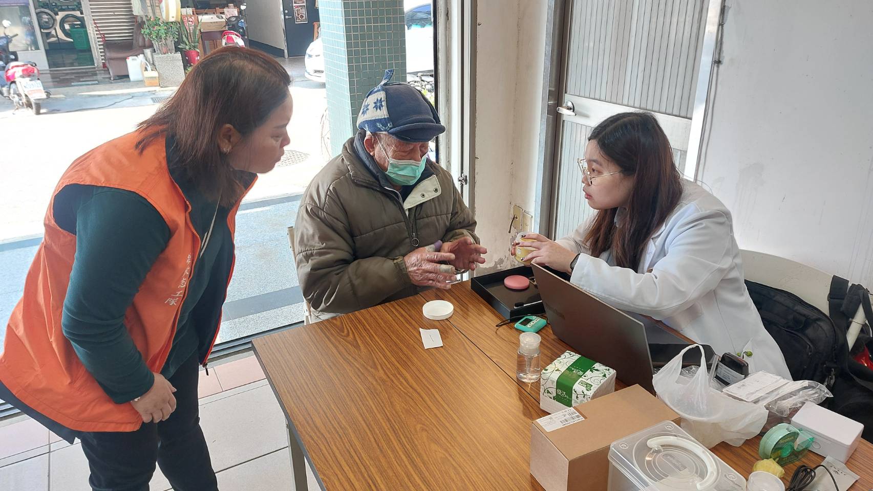 圖六志工(左1)協助榮民接受助聽器服務