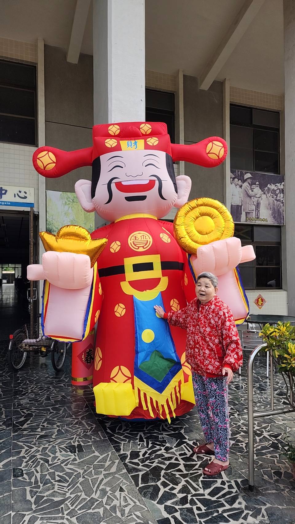 圖2:屏東榮家長輩與財神爺Q版娃娃合影,現場氣氛歡樂」。