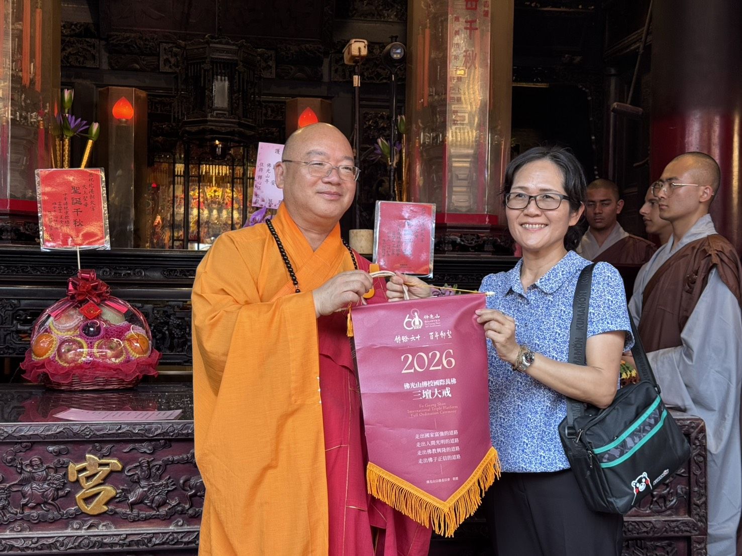 佛光山住持心保和尚(左一)授贈行腳紀念給薛家玲總幹事(右一)