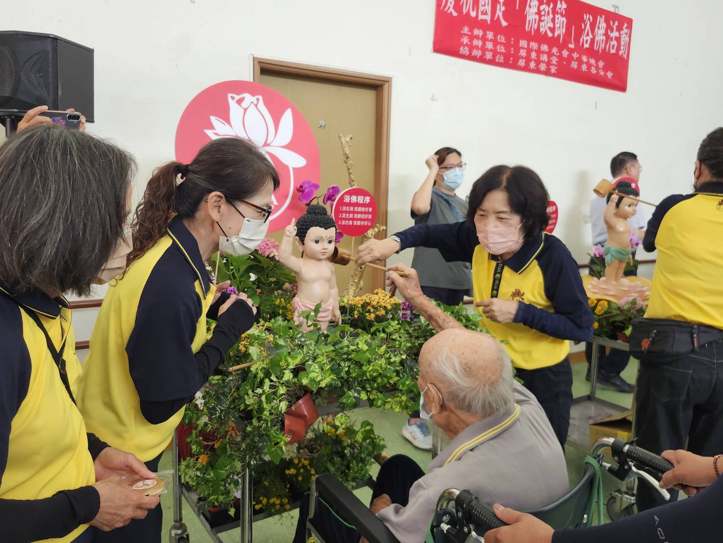 圖4志工協助行動不便長輩參與浴佛祈福