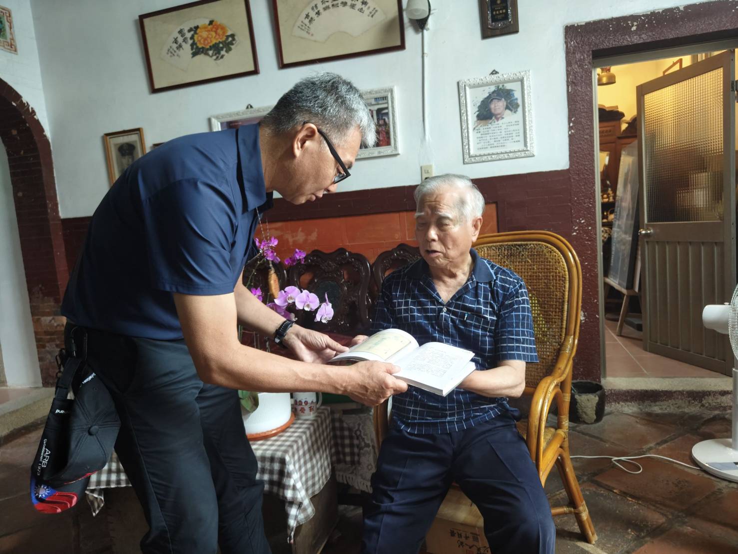 圖九輔導會簡任視察李惠寧先生(左)探視榮民林馬騰先生(右)了解榮民文物收藏情形