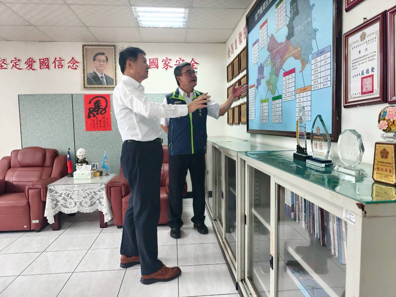 圖三輔導會服務照顧處羅籝洋處長(左)視導金門榮服處,由處長劉信義(右)解說金門地區榮民現況