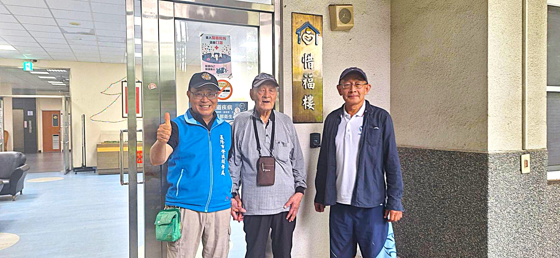 本處護送人員社區服務組長江有維(左)與榮民褚伯伯(中)及其陪同之二公子,於申請入住板橋榮家惜福樓房舍前合照。