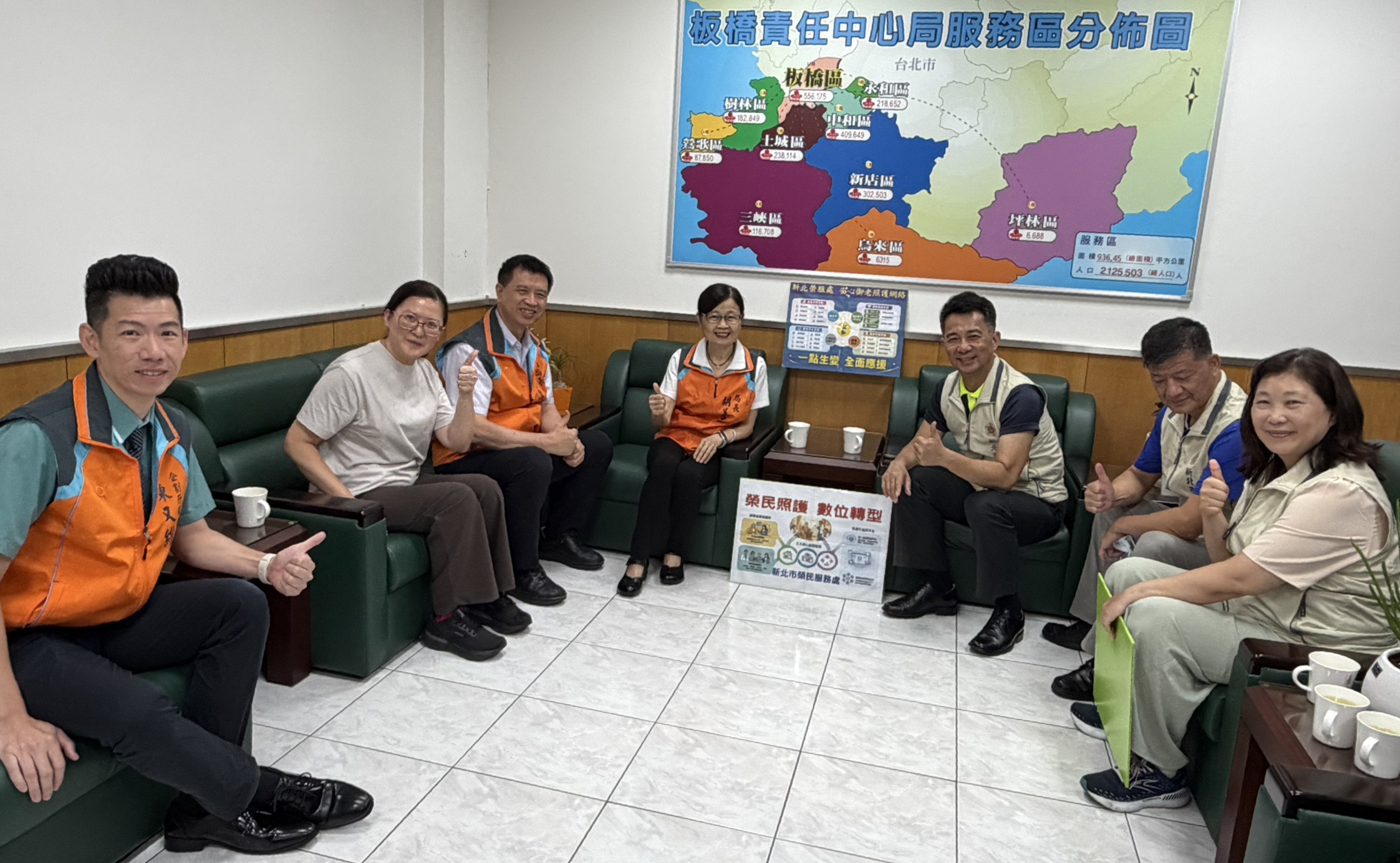 ▲處長陳立中(右3)率副處長楊懷博(右2)、總幹事吳曉慧(右1)向板橋郵局局長胡美惠(中)及副局長曾清潭(左3)行銷科科長林佳華(左2)、副科長陳又維(左1)親自說明輔導會「安心御老平台」專案。
