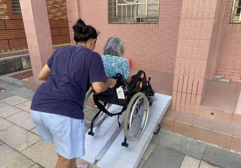 圖二外籍看護親推黃阿嬤體驗斜坡道