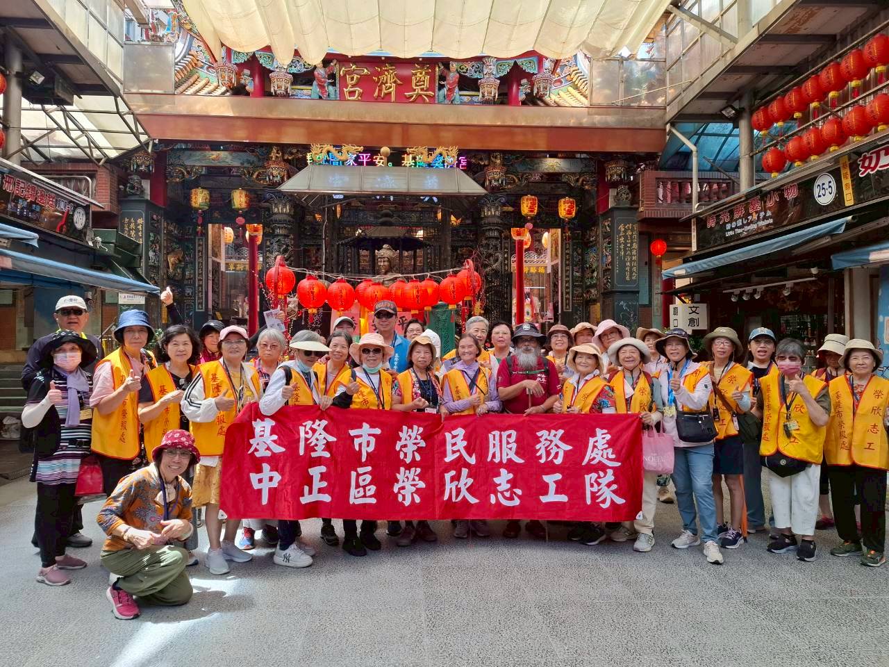 基隆社大女路走讀導覽老師李正仁老師(著紅衣者)及方正處長(中,著藍衣者)偕同榮欣志工於基隆廟口重要宗教景點-奠濟宮,歡喜合影