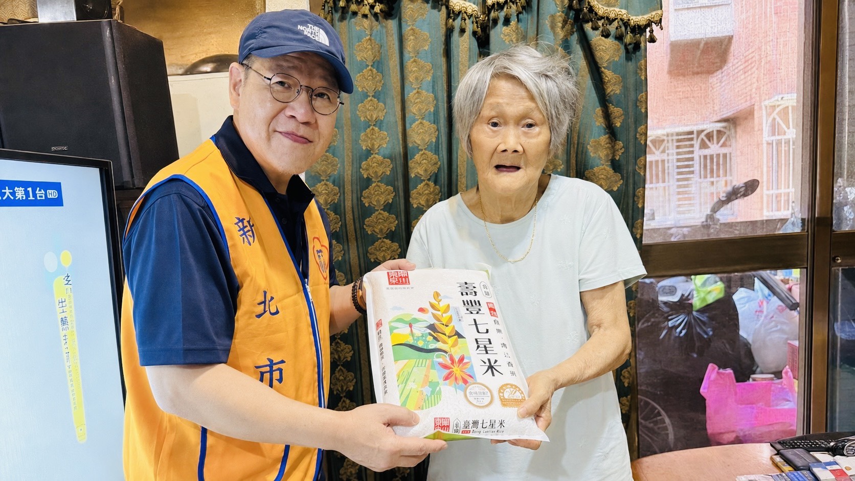 ▲新北市榮服處榮欣志工(左)將仙聖宮捐贈的平安米親送至榮民眷家中,傳遞秋節關懷與溫暖。/新北市榮民服務處提供。