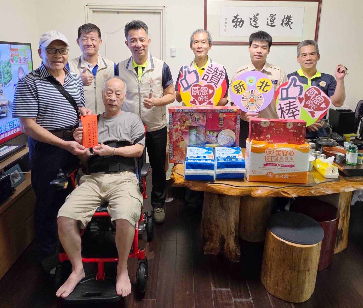 ▲新北市榮民服務處陳立中處長(後排右四)率楊懷博副處長(後排右五)、輔導員、替代役等服務團隊,偕同輝容基金會吳坤德執行長(前排左),關懷慰問榮民鄭先生(前排右),吳執行長代表該基金會致贈慰問金。