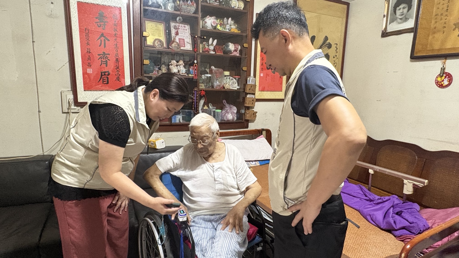 ▲陳立中處長(右一)率領服務團隊運用心律儀量測生命徵象,關心其健康狀況。/新北榮服處提供。