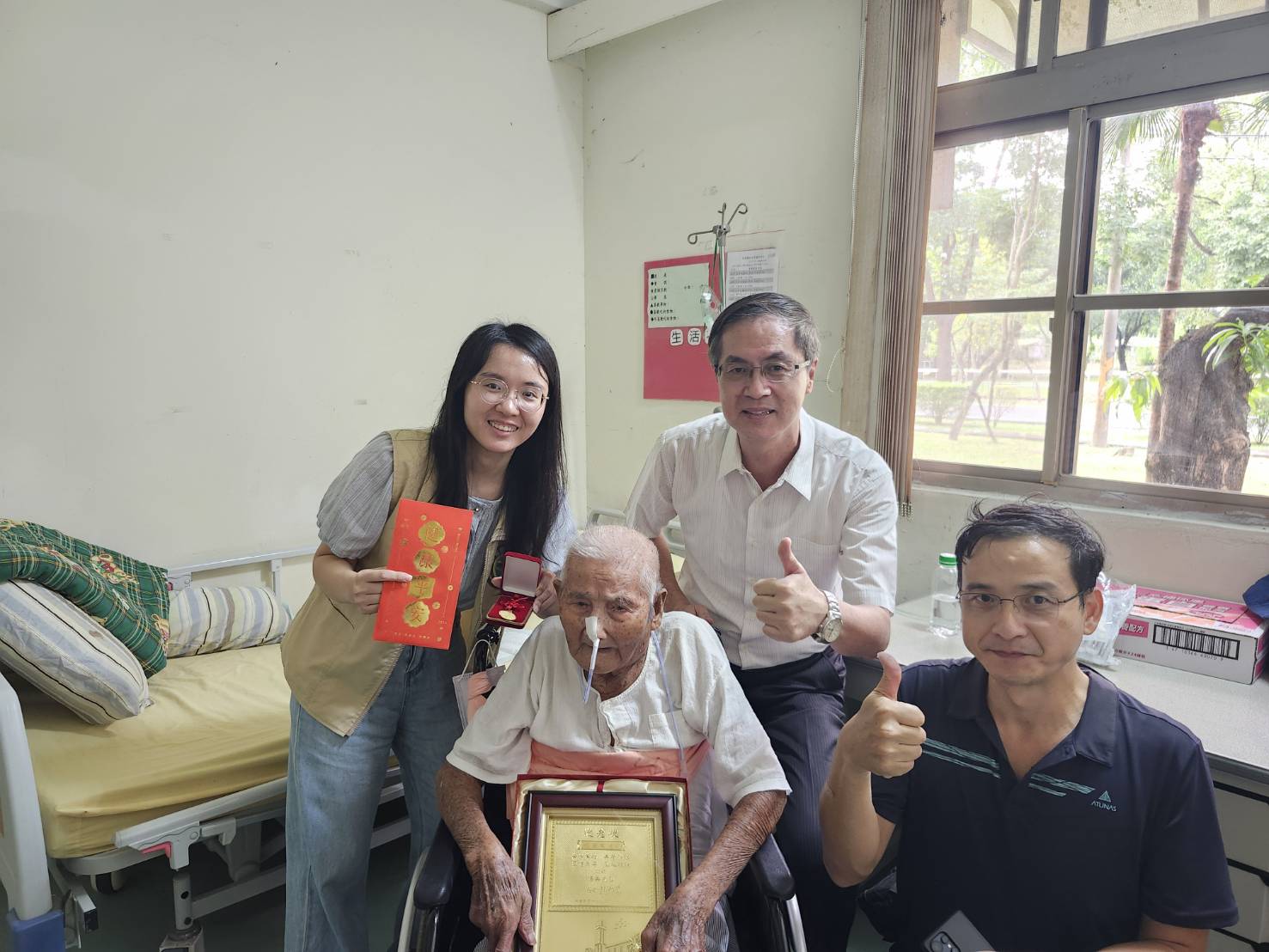 圖2:屏東榮家主任李秦強(右2)陪同榮民百歲人瑞長接受屏東縣政府致贈敬老狀及敬老金合影留念